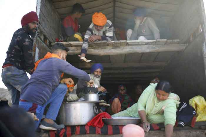 各地农民前往德里路途中，在卡车上留宿、用膳，拒绝退让。