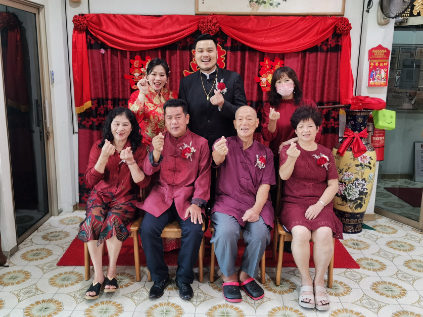 马芷琳（站者左起）及李伟政在王美莲主持见证下，完成注册结婚仪式，并与双方家长分享喜悦。