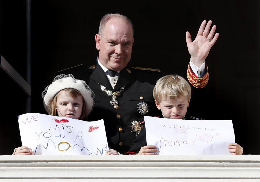 摩纳哥亲王阿尔贝二世（中）带着小公主加布里埃拉（左）、小王子雅克秀出要给妈妈看的字卡。（欧新社）
