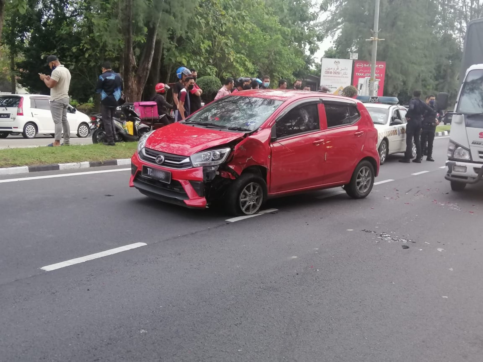 在路上横冲直撞的红色国产轿车，车头部分损毁。