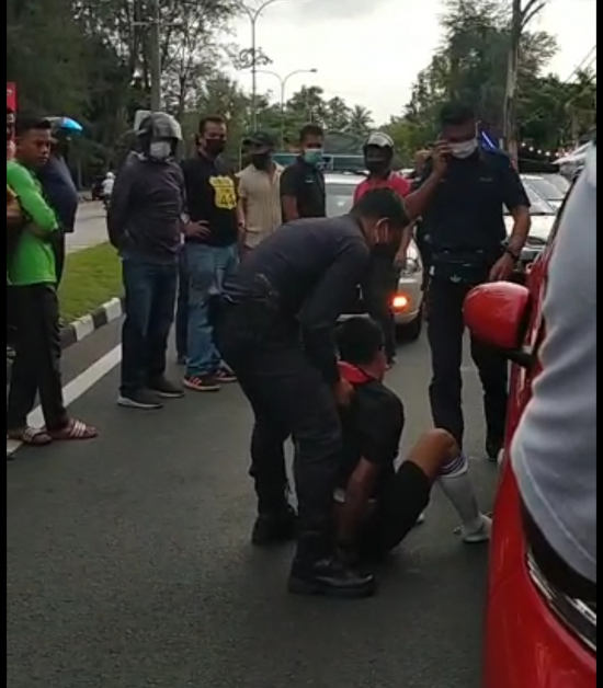 其中一名青年被警方扣留时，一度跌坐在马路上。