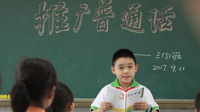 一名学生在课堂上参与推广普通话的活动。（档案照）