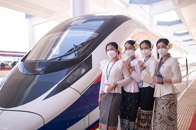 寮国工作人员周四在永珍车站的“澜沧号”动车组前留影。（新华社）