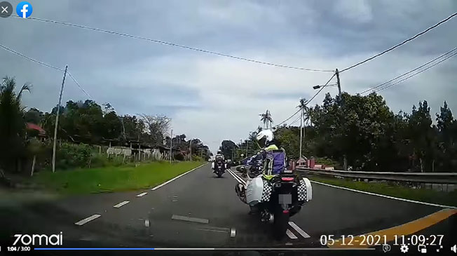 视频截图可见，一名摩哆骑士伸出手指示轿车司机慢行及停靠到左边路旁。