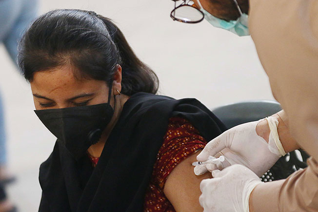 巴基斯坦一名女子在卡拉奇市接种新冠疫苗。（欧新社）