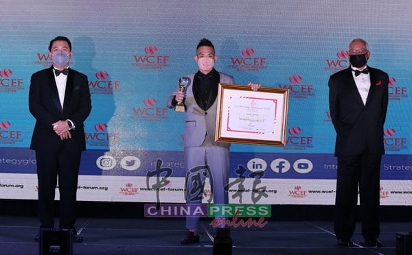 谢儮好（中）接领世界华人杰出体育成就奖，右起为纳吉和谢泉勇。