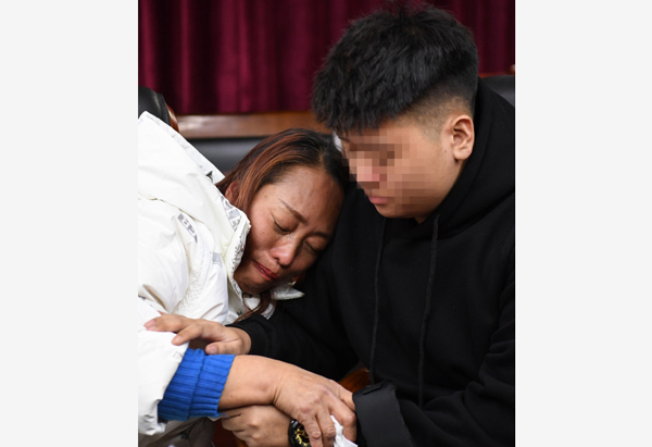 在广州公安局花都区分局，罗艳（左）与儿子手拥抱在一起。（新华社）