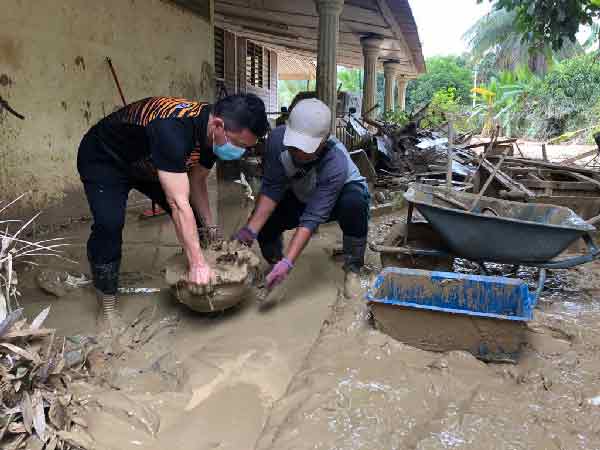 郑联科（左）与青年之友及志工，协助清理其中一间受灾房屋。