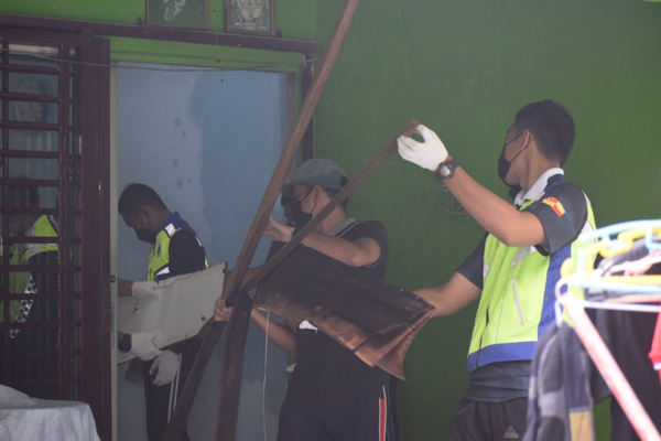警员帮忙灾黎清理家中损坏的物品。