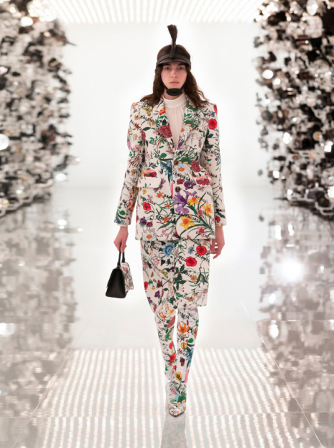 Gucci Aria系列向Balenciaga创意总监Demna Gvasalia致敬，将巴斯克腰线外套与袜靴等标志商品印上满满的Flora印花。