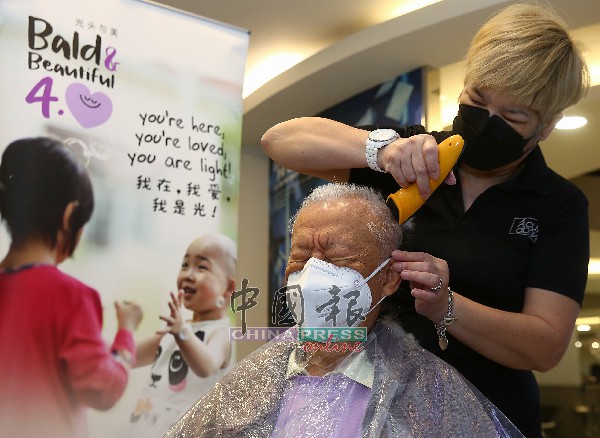 91岁的黄崇锐（左）身体力行参与落发。