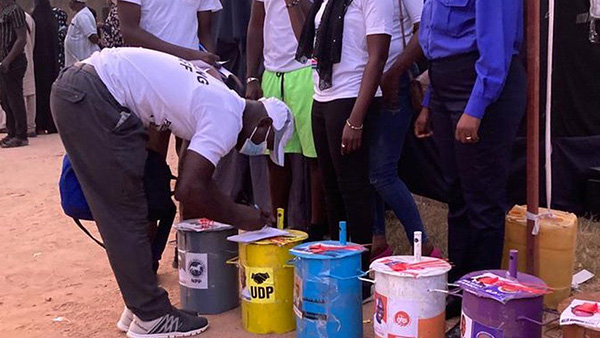 将弹珠塞入有候选人照片的桶子，就是冈比亚的选举投票方式。