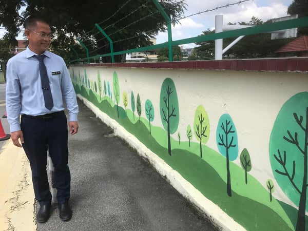 黄校长为育华小学校园亲自画上壁画。