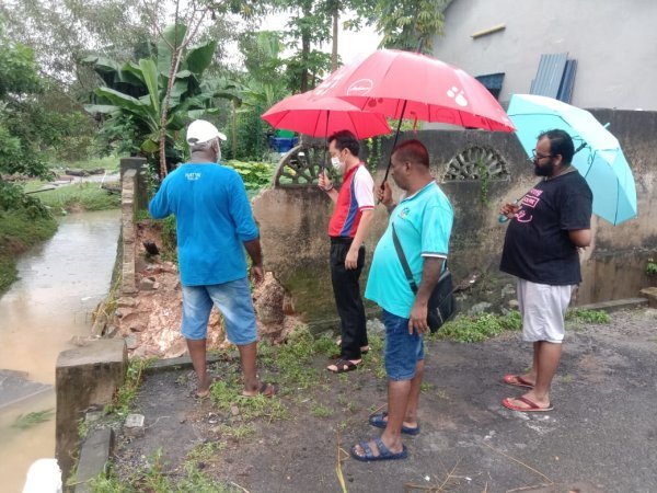 谢琪清（左2）在居民的陪同下，巡视迪沙珍巴卡的水灾灾情。