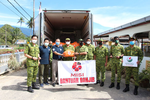 唐锐（左3）在志愿警卫队成员陪同下，准备将救济物资交给灾民。