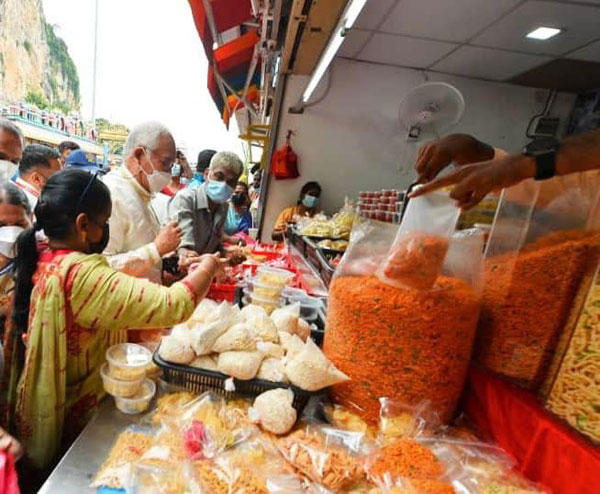 纳吉（左2）在黑风洞的小食摊位，应节购买印度小吃。