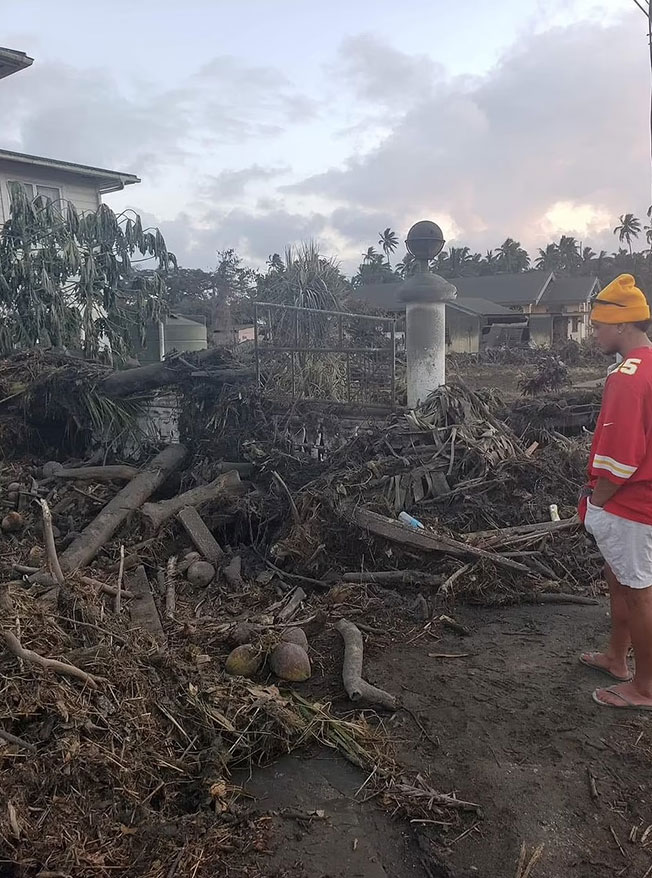 汤加居民无奈地望着被摧毁的住所。