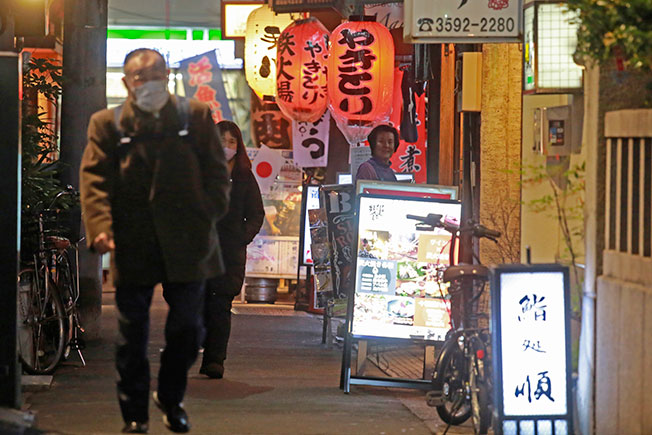 日本民众戴着口罩到东京的餐厅和酒吧。（美联社）