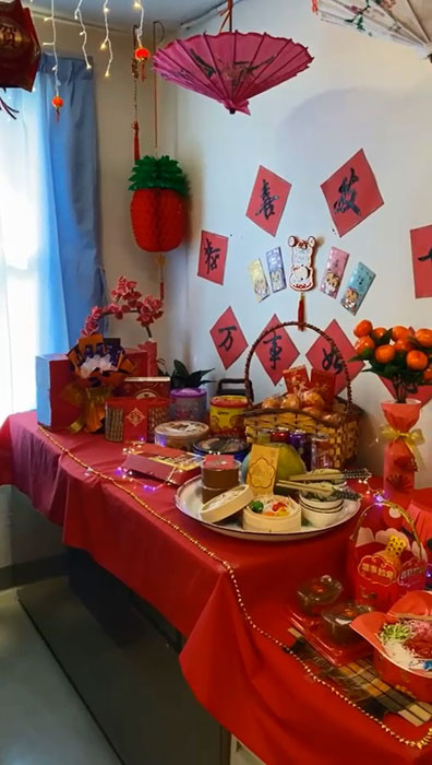 桌子上摆满了年饼、年柑、年糕和红包，非常应节。