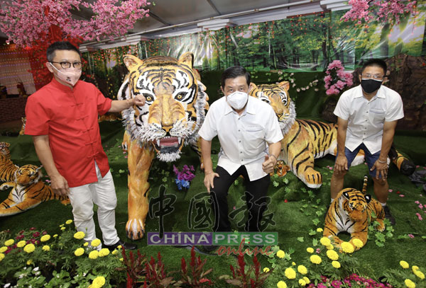 千百家居士林理事配合虎年，打造2只大老虎模型，供访客拍照打卡。左起郑联科、潘文俊及黄椗强。