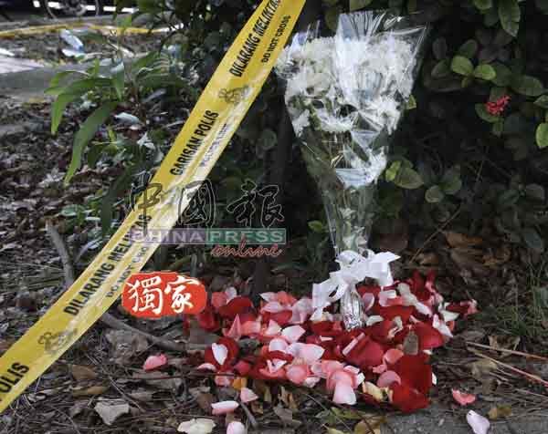 死者家属在案发现场留下一束白菊花和红花瓣。