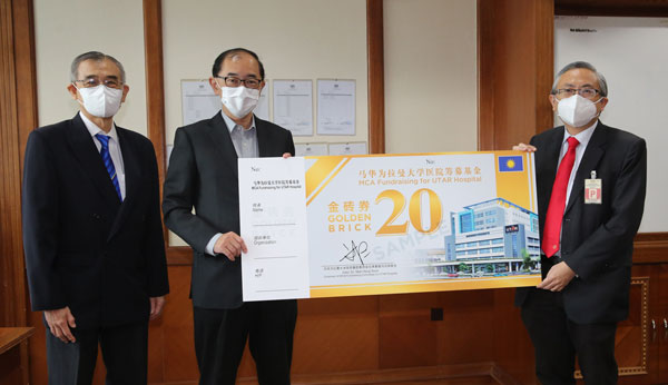 马汉顺（中）与尤芳达（右）展示为拉曼大学医院筹款的“金砖券”，每张面额为20令吉，届时将以义卖方式售卖，向公众筹款；左为张顺景。