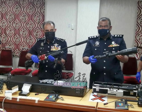 阿都马吉（左起）与阿斯兰，查看警方在行动中起获的仿真气枪。