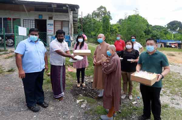 森州琉璃胜成佛行协会主席刘雪燕（左3）配合马华到水灾区分派饭盒予受影响灾民。
