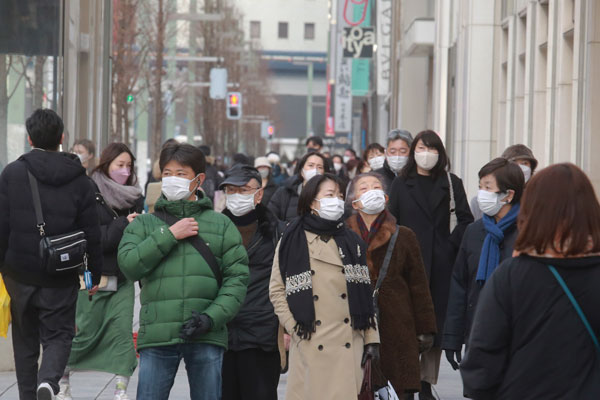 周三在东京街头，每个行人都戴着口罩。（美联社）