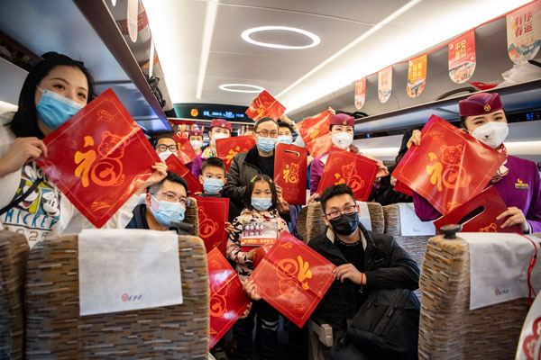 成渝高铁“复兴号”智能动车组“共青团号”列车17日首发，旅客在列车上展示小礼品。（新华社）
