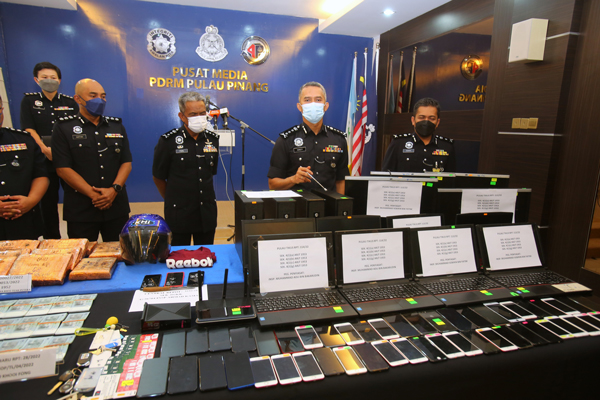 苏海利（左3）在记者会上展示，警方起获的非法网上赌博集团干案工具，左起为苏菲安及菲索尔。