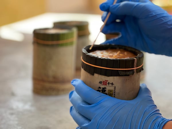 年糕用筷子装入竹筒后，还要用竹签将气泡扎破，待凉了之后就完成了。