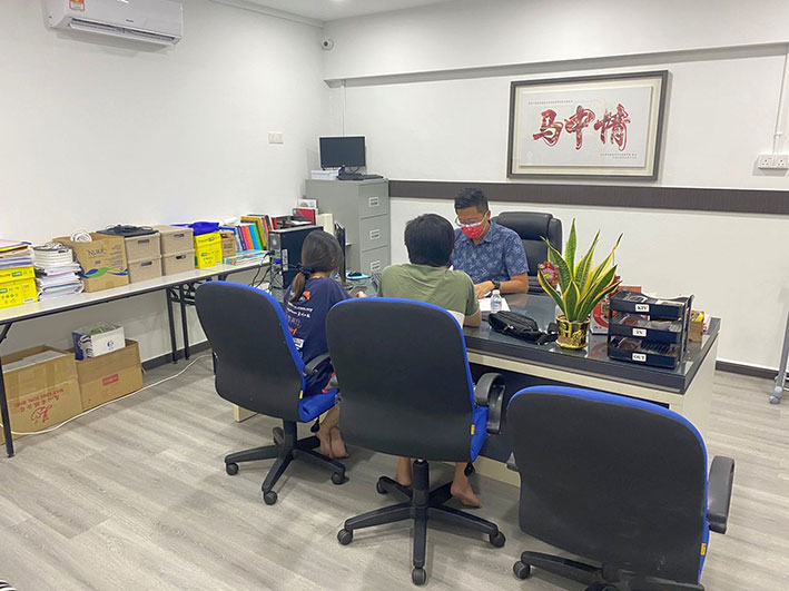 被骗走电子钱包钱财的兄妹（背向镜头），向谢守钦投诉。