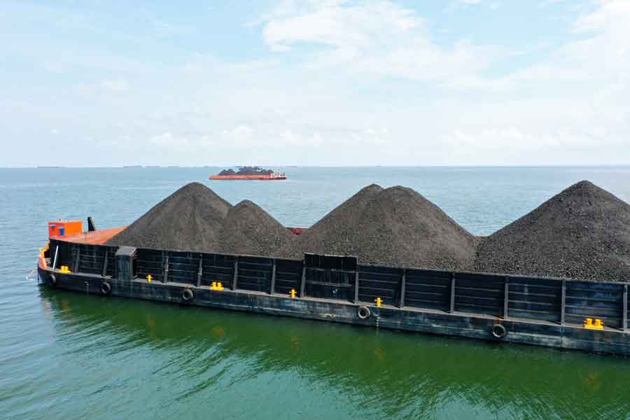 煤炭在内的燃料价格高涨,推高了我国发电成本;图为印尼岸外一艘满载煤炭的驳船。