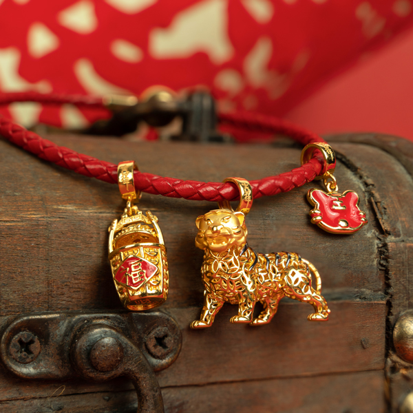 以红色手绳串多个吉祥饰品，组成一条玲珑讨喜的手链，红金两色喜气又祥和。