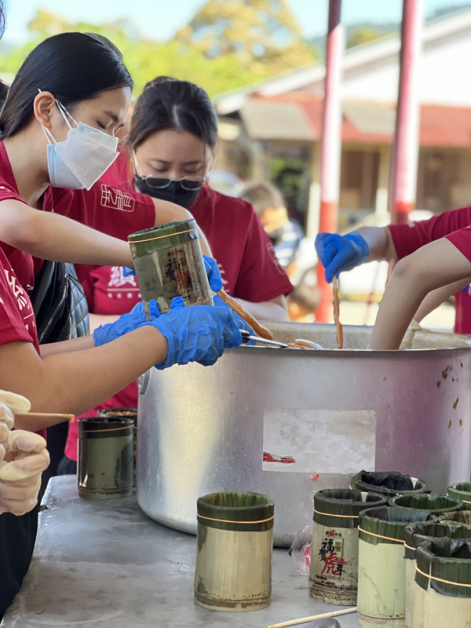 年糕出炉后大家分工合作，在年糕凝固前用最快的速度装入竹筒。