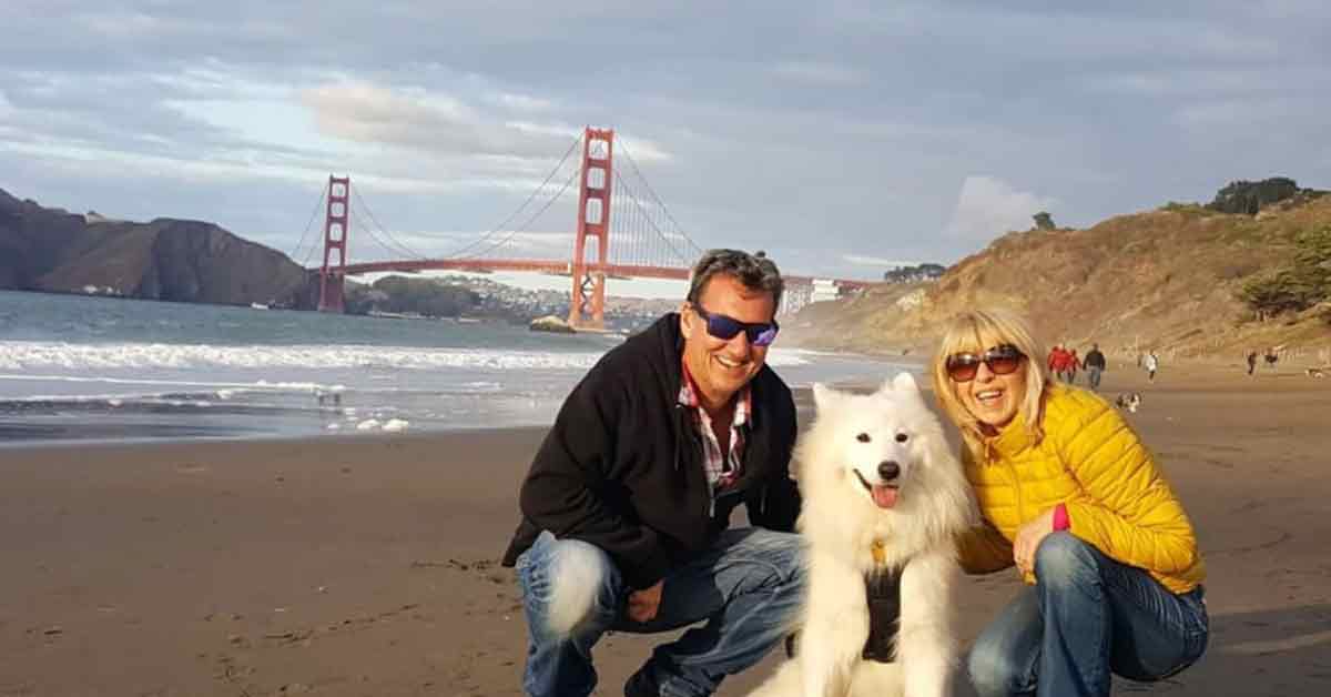 夫妇俩与狗狗在美国旧金山金门大桥附近合照。