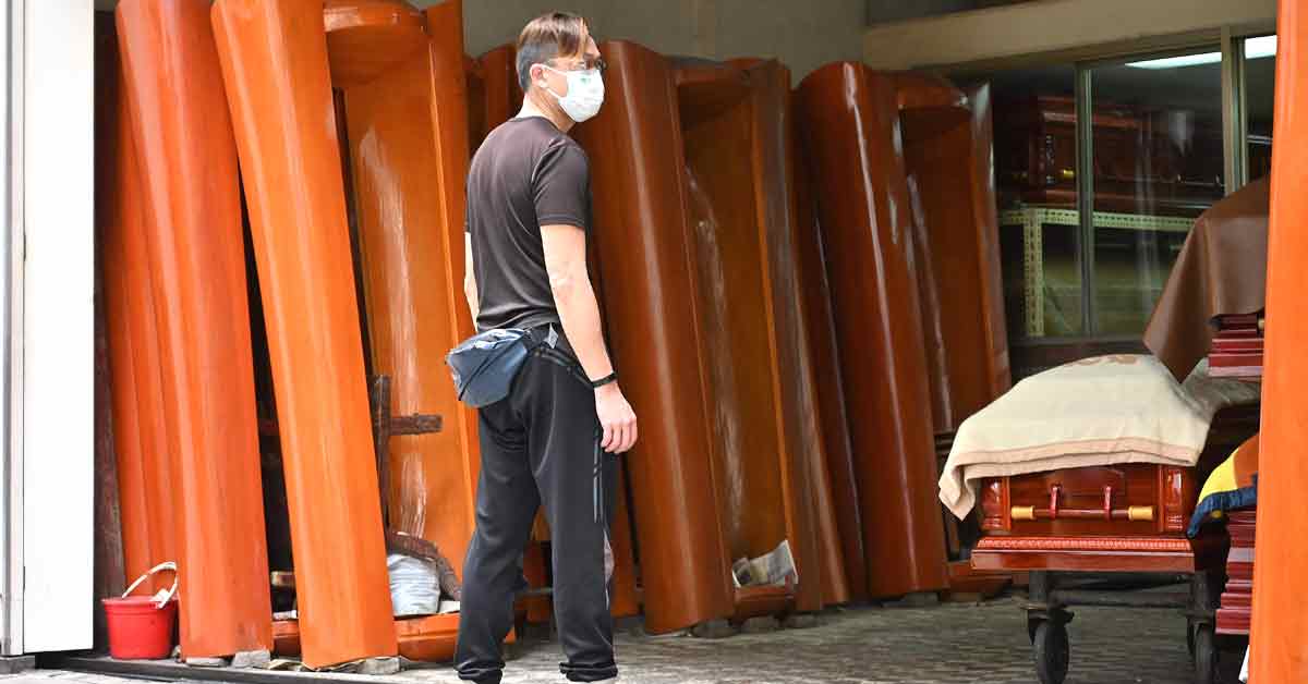 周三在香港一家殡仪馆，一名男子站在棺材前若有所思。（法新社）

