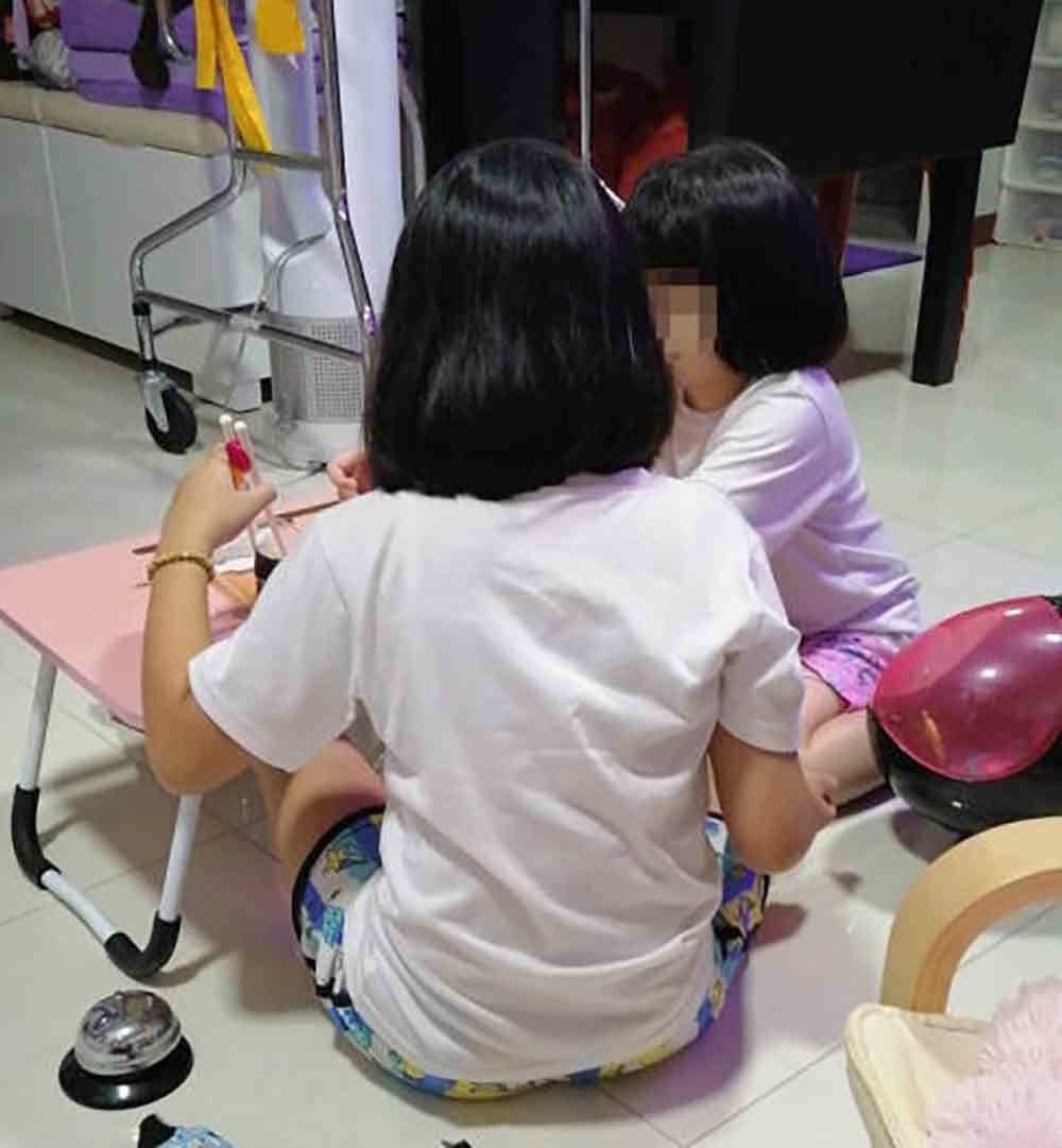 女童（左）事发后在家中休养，图为她和妹妹玩游戏。（档案） 