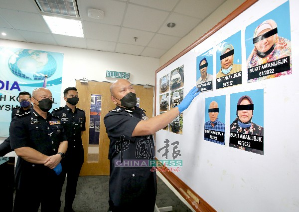 卡马鲁丁（右）向记者展示警方起获的轿车及落网的首脑照片。