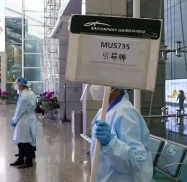 机场工作人员手持“MU5735引导牌”静默站立。