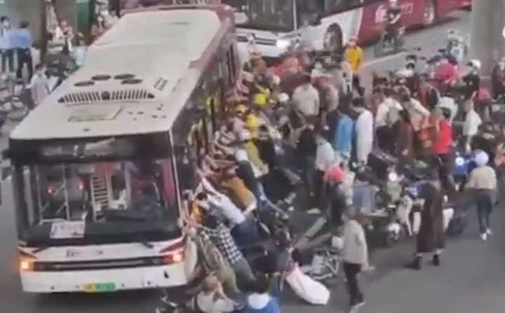 近百名群众立即上前试图抬起巴士救人。