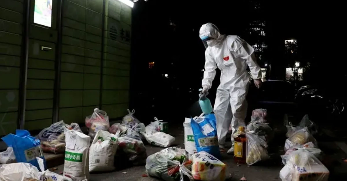 上海一处社区的防疫志工，为居民的物资进行消毒。（新华社）