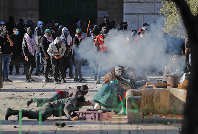 在耶路撒冷老城区的阿克萨清真附近，一群蒙面的巴勒斯坦人周五向以色列警察抛掷石块，事件演变成冲突。（法新社）