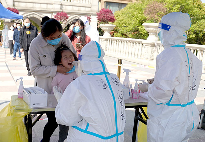 在上海嘉定区南翔镇一小区内，来自海南的援沪医务人员，4月6日在为居民进行核酸检测。