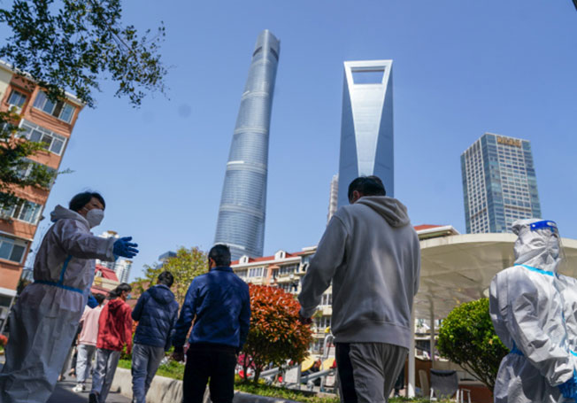 在上海市浦东新区东一居民区，市民4月4日在排队进行核酸检测采样。