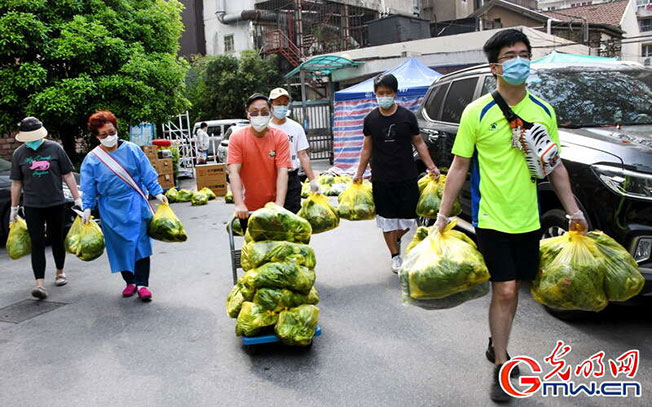 上海小区志愿者在为居民送团购物资。