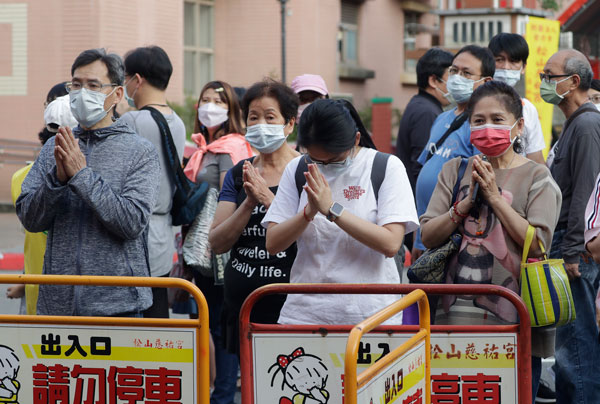 台北民众周六在一所庙宇外膜拜。（美联社）