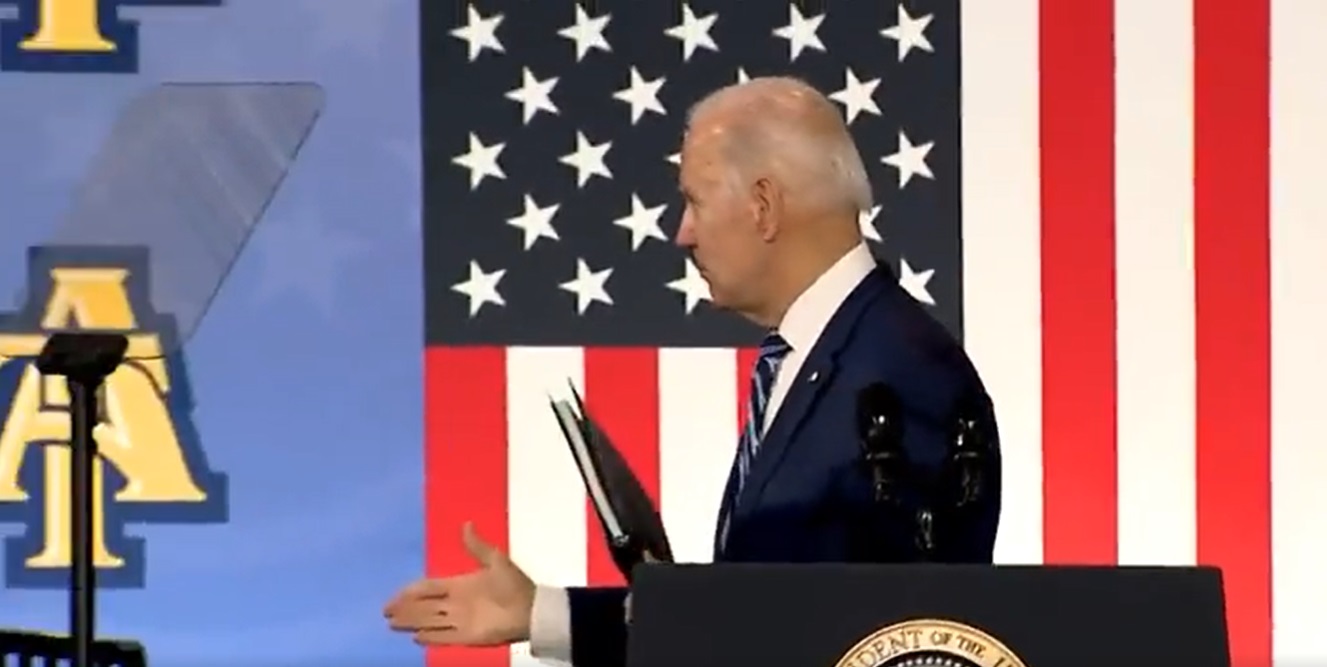 美国总统拜登14日在台上与空气握手的画面。
