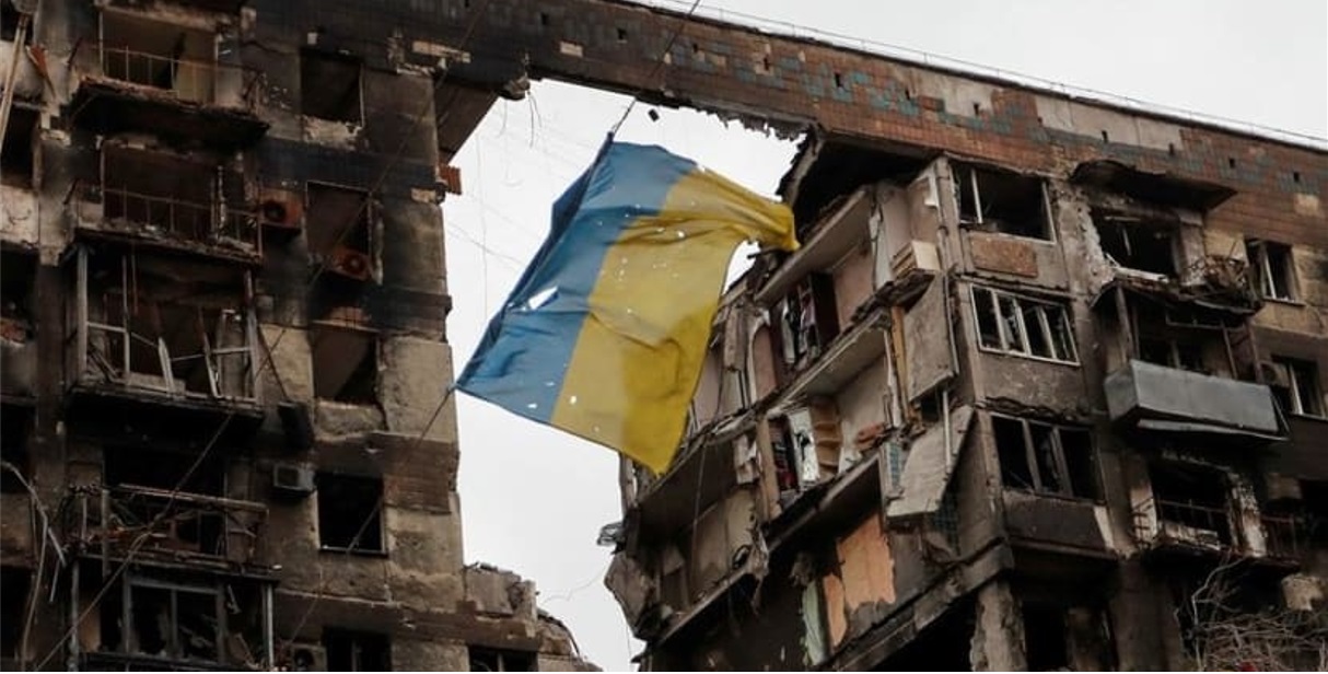 马里乌波尔一座公寓楼前的乌克兰国旗破烂不堪。